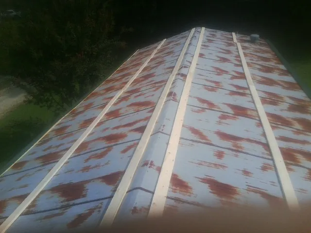 Rusted metal roof panels with new wood purlins before replacement — Storm Damage Roof Repair in Gadsden by Roofing Brothers