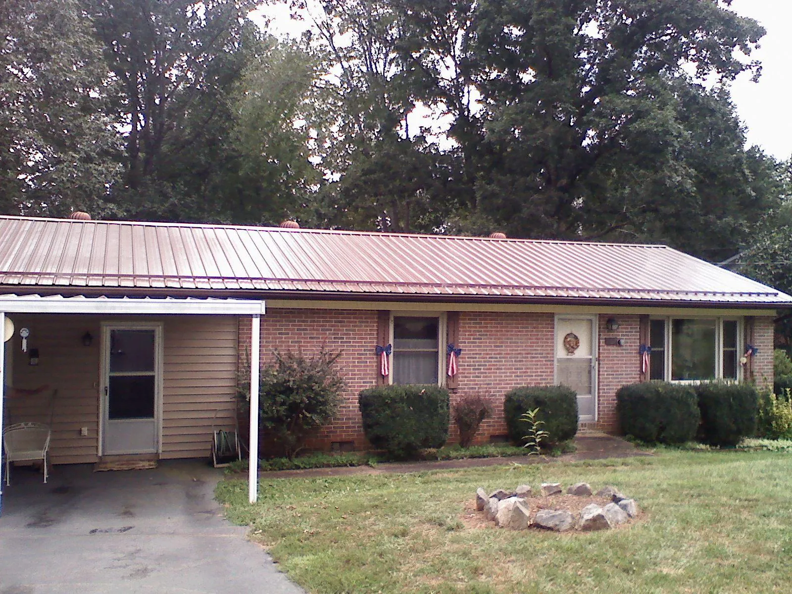 Bronze metal roof and carport on a brick ranch home — Roof Repair work by our crew in Gadsden