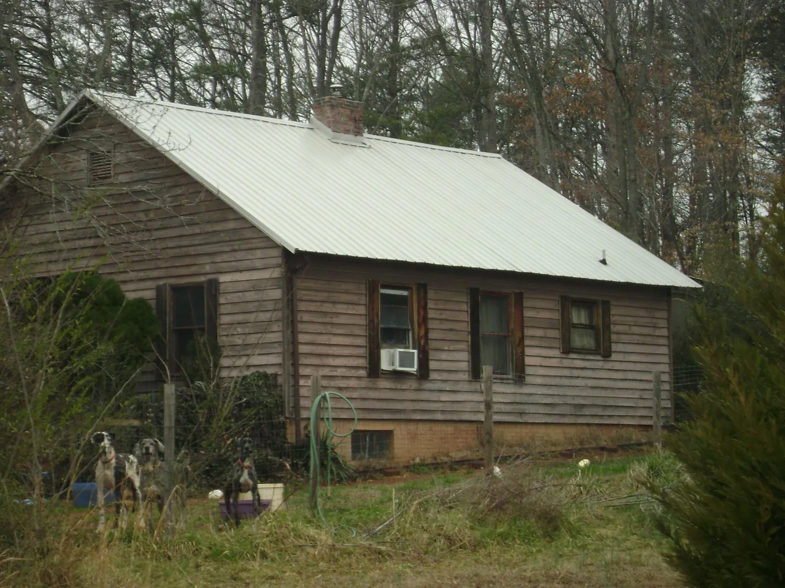 White metal roof on an old wood sided farmhouse, from a Metal Roof Installation job in Gadsden